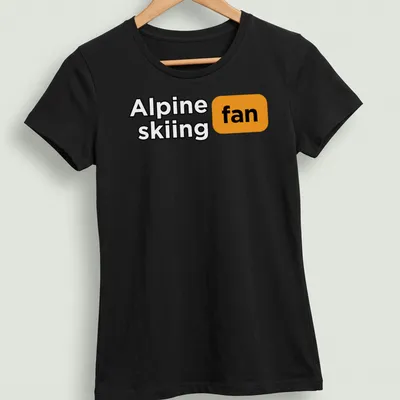 Bold graphic Alpine skiing fan t-shirt with dynamic skiing illustration in black, orange, and white — printed on a women's shirt