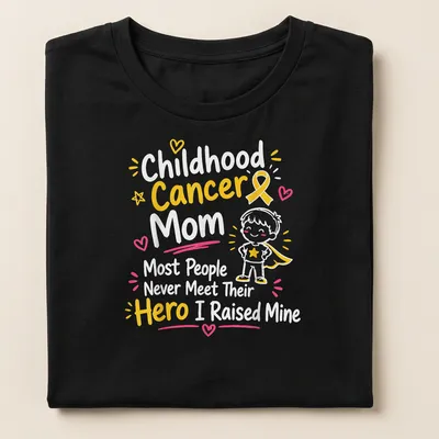 Cartoon superhero boy with text celebrating childhood cancer moms — printed on a women's shirt