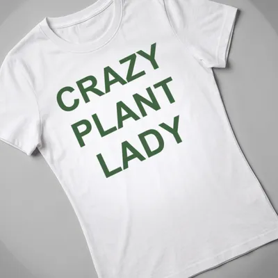 Bold typography CRAZY PLANT LADY shirt with green text on white background — printed on a women's shirt