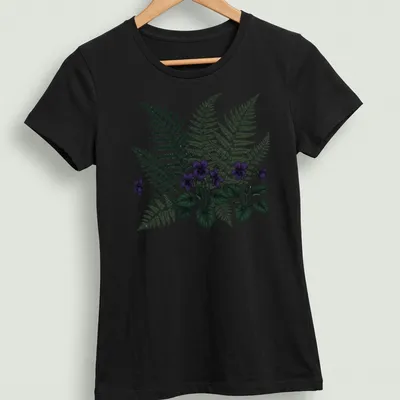 Moody botanical print featuring purple violets and ferns with elegant text. — printed on a women's shirt