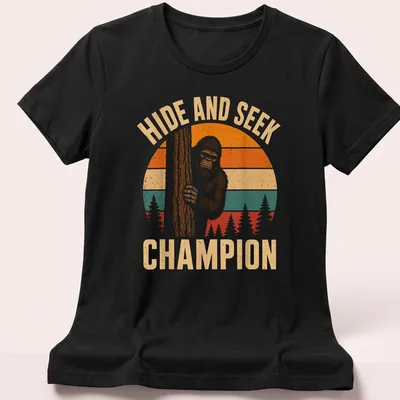 Retro vintage Bigfoot Sasquatch t-shirt with playful text above cartoon art — printed on a women's shirt