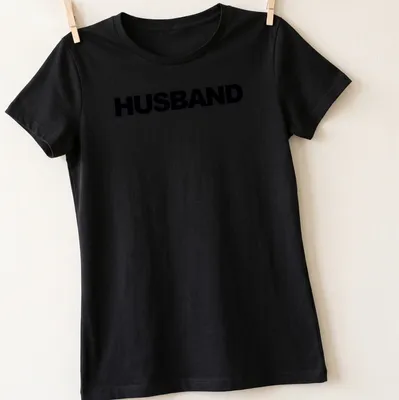 Minimal bold black HUSBAND text on a — printed on a women's shirt