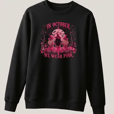 Vintage illustration of three witches with the text 'In October We Wear Pink' — printed on a unisex sweatshirt