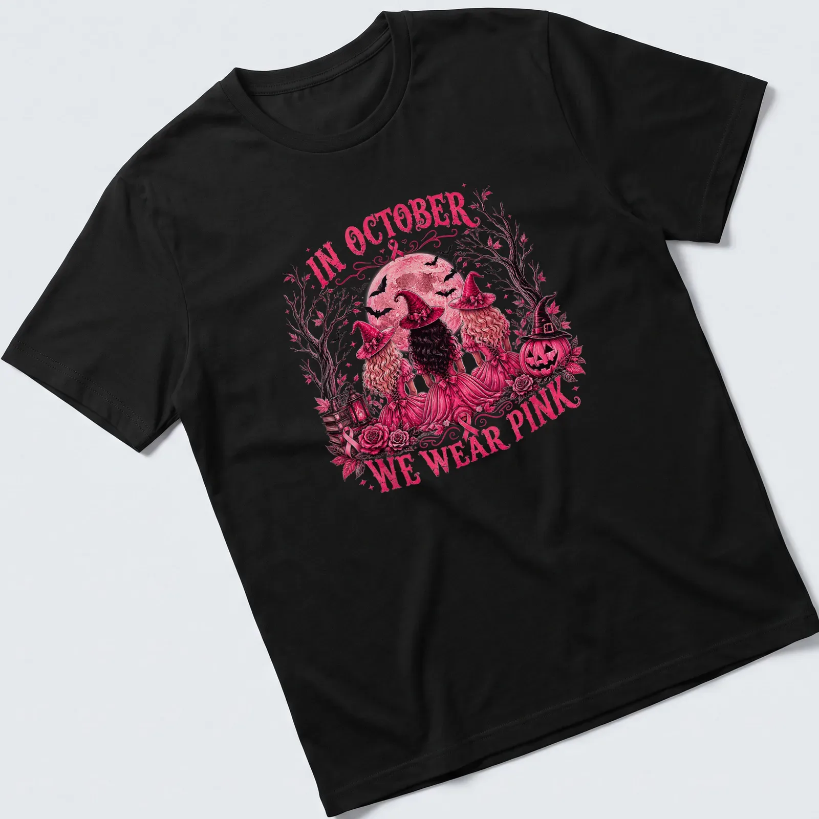 Vintage illustration of three witches with the text 'In October We Wear Pink' — printed on a unisex t-shirt