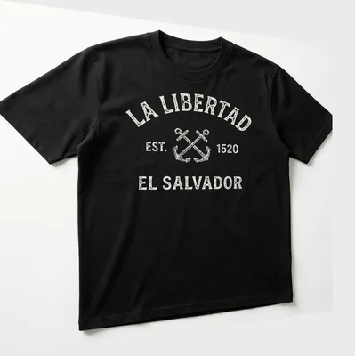 Vintage design featuring crossed anchors and text honoring La Libertad, El Salvador. — printed on a unisex t-shirt (angled view)
