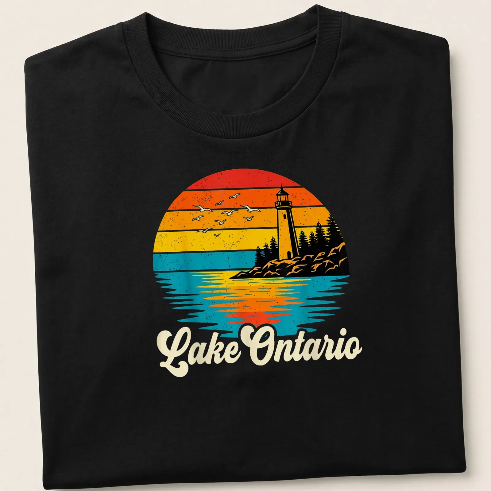 Retro sunset scene featuring a lighthouse with seagulls and the text 'Lake Ontario' in stylized lettering — printed on a unisex t-shirt