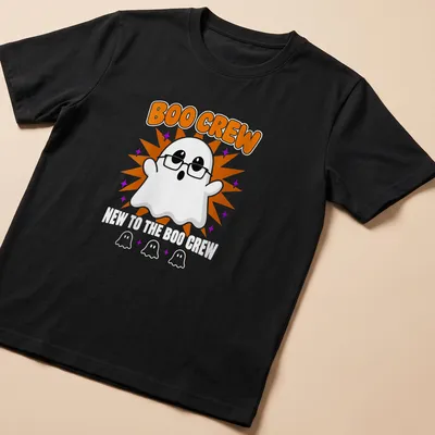 Cartoon ghost graphic with text 'New To The Boo Crew' in orange and purple — printed on a unisex t-shirt