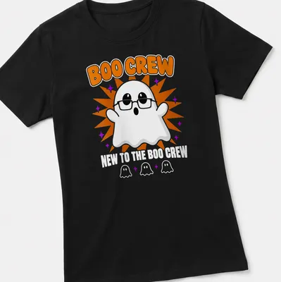 Cartoon ghost graphic with text 'New To The Boo Crew' in orange and purple — printed on a women's shirt