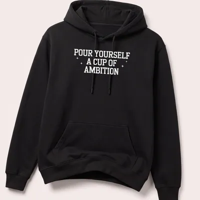 Inspirational t-shirt with bold text 'Pour Yourself A Cup Of Ambition' and a coffee cup illustration — printed on a unisex hoodie