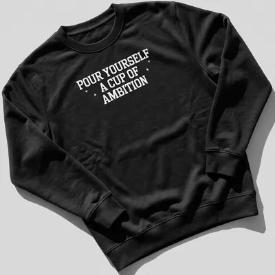 Inspirational t-shirt with bold text 'Pour Yourself A Cup Of Ambition' and a coffee cup illustration — printed on a unisex sweatshirt