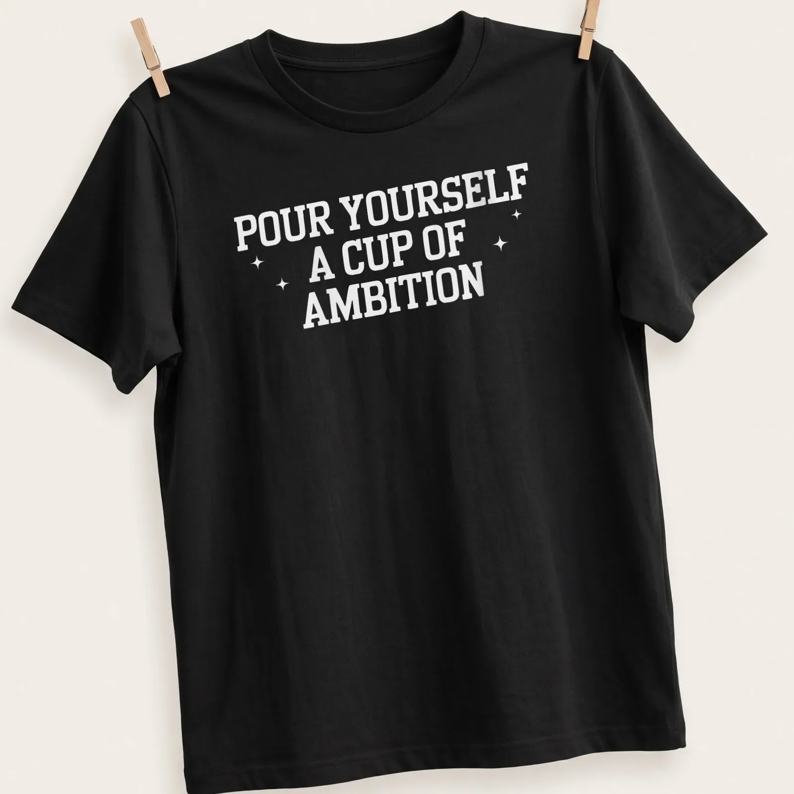 Inspirational t-shirt with bold text 'Pour Yourself A Cup Of Ambition' and a coffee cup illustration — printed on a unisex t-shirt