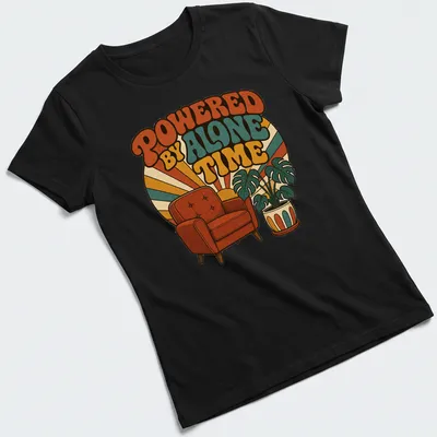 Retro design featuring an armchair and potted plant with the text 'Powered By Alone Time' — printed on a women's shirt