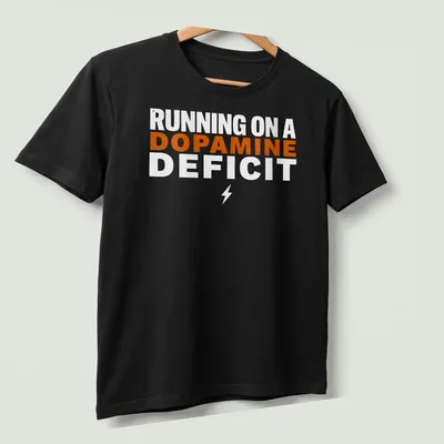 Bold typography humor t-shirt with the phrase 'RUNNING ON A DOPAMINE DEFICIT' in orange and white. — printed on a unisex t-shirt (angled view)