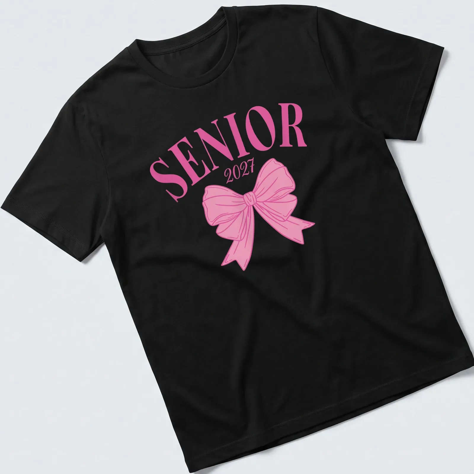 Aesthetic graduation t-shirt with SENIOR 2027 text and a pink bow — printed on a unisex t-shirt