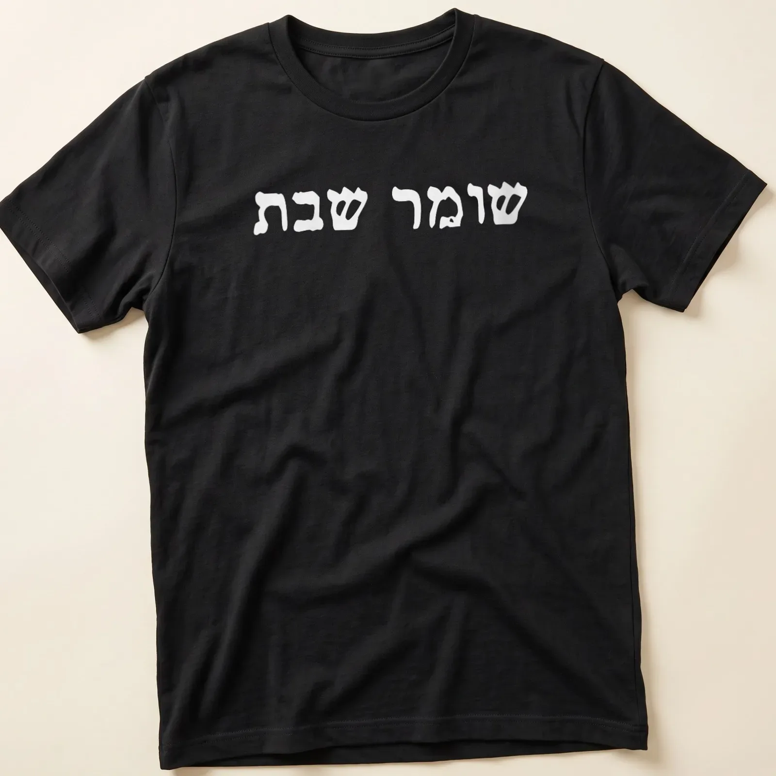 Minimalist Hebrew text reading Shomer Shabbat Shalom on white — printed on a unisex t-shirt