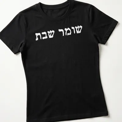 Minimalist Hebrew text reading Shomer Shabbat Shalom on white — printed on a women's shirt