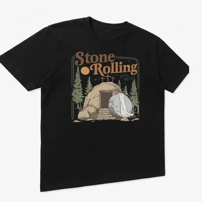 Vintage illustration of an empty tomb with a rolled stone and crosses, featuring the text Stone Rolling Since AD 33 — printed on a unisex t-shirt (angled view)