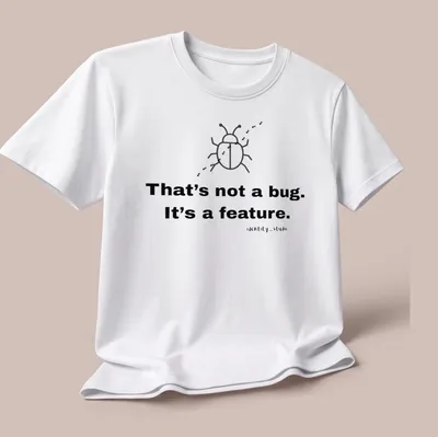 Simple line-art beetle with text 'That's not a bug. It's a feature.' — printed on a unisex t-shirt (angled view)