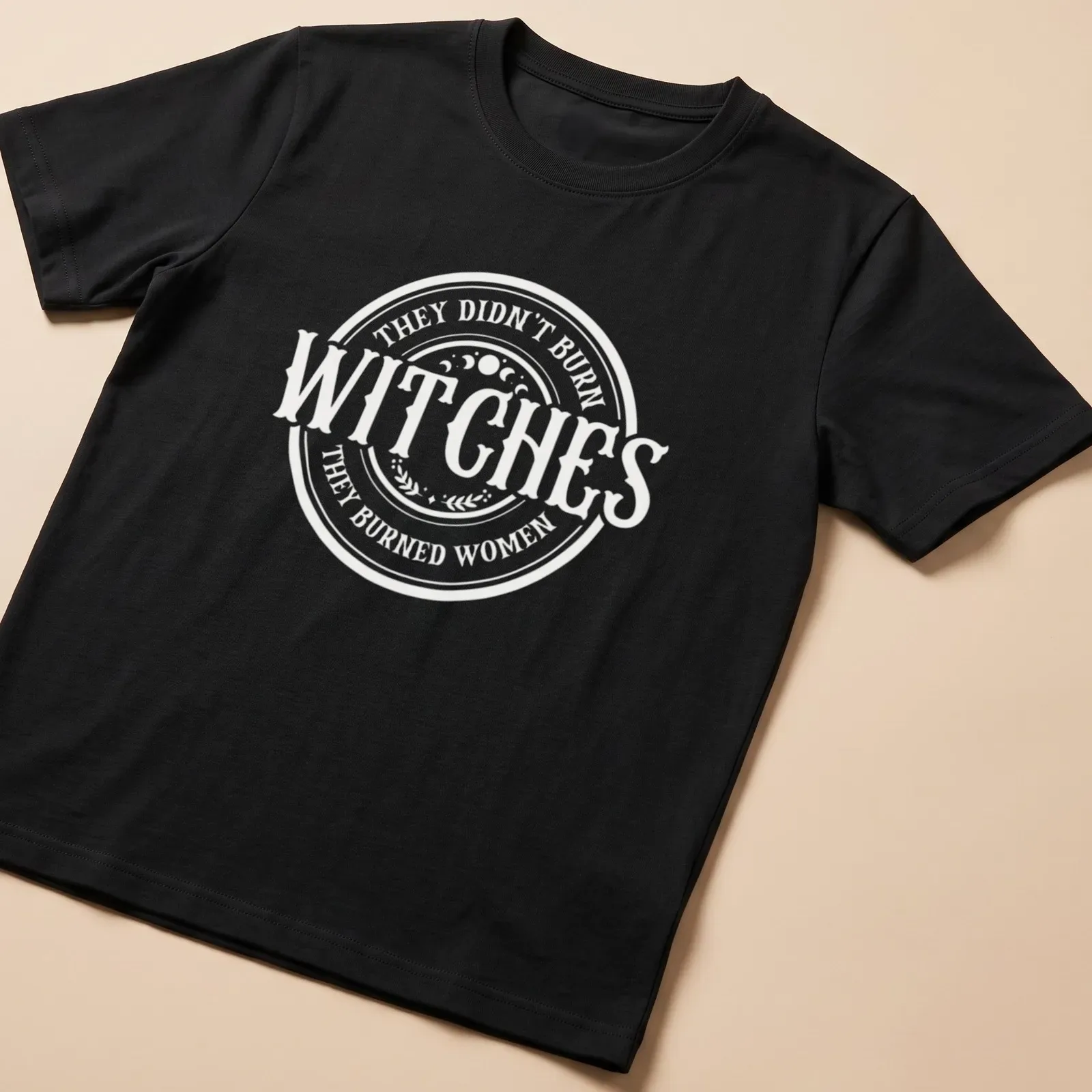 Circular typography shirt with the text about witches and women in white and light beige — printed on a unisex t-shirt