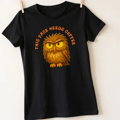 Cartoon grumpy owl with text 'This Face Needs Coffee' in brown, yellow, and orange — printed on a women's shirt