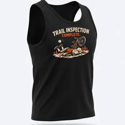 Playful illustration of a mountain biker with the text 'Trail Inspection Complete' in orange and cream tones. — printed on a tank top