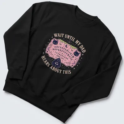 Whimsical T-shirt design featuring Ouija board and playful cats with humorous text. — printed on a unisex sweatshirt