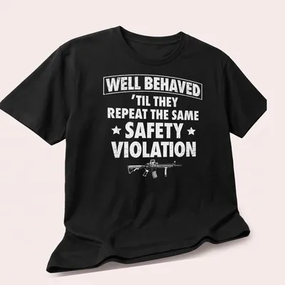 Bold text reading WELL BEHAVED with rifle graphic on a black — printed on a unisex t-shirt (angled view)