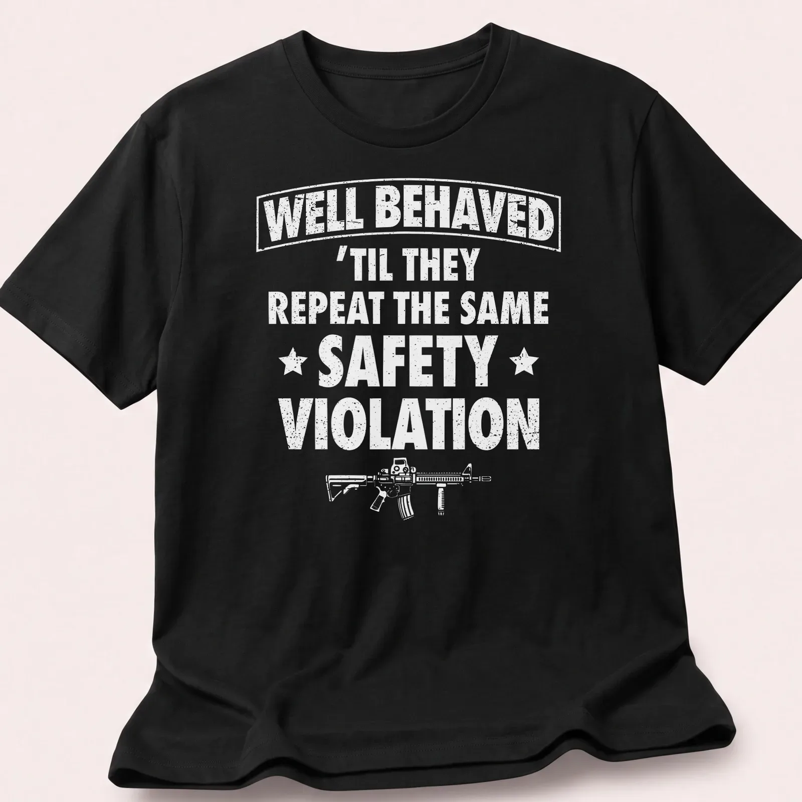 Bold text reading WELL BEHAVED with rifle graphic on a black — printed on a unisex t-shirt