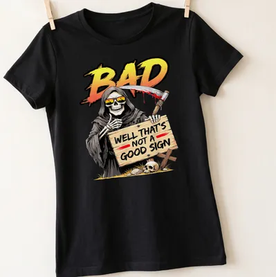 Cartoon Grim Reaper holding a skull with colorful text above — printed on a women's shirt