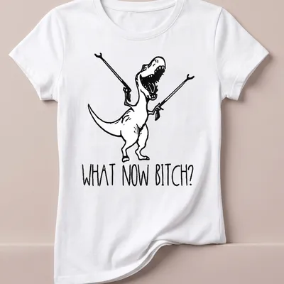 Cartoon T-Rex with bold text 'WHAT NOW BITCH?' in black and white — printed on a women's shirt